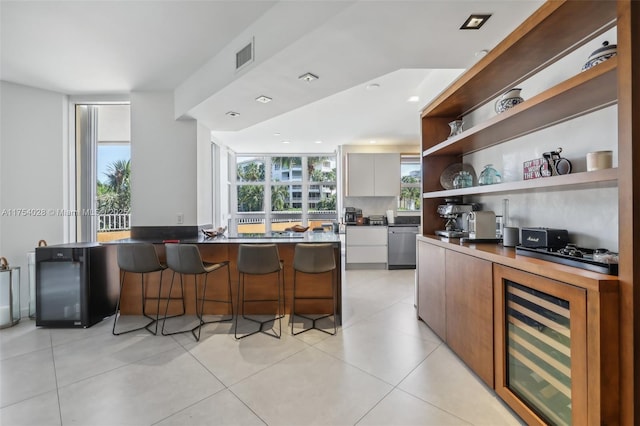 kitchen featuring beverage cooler, a breakfast bar, visible vents, open shelves, and modern cabinets