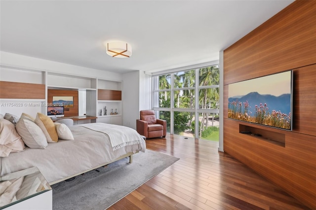 bedroom featuring floor to ceiling windows and wood finished floors