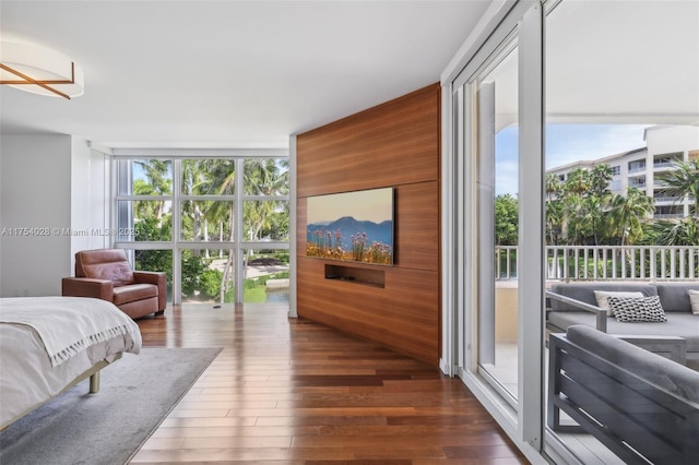 bedroom featuring access to exterior, floor to ceiling windows, and dark wood-type flooring