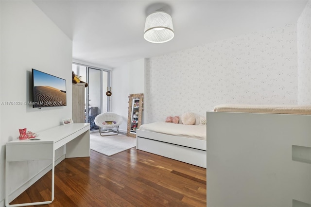 bedroom with expansive windows, wood-type flooring, and wallpapered walls