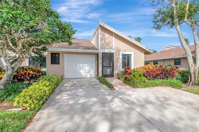 mid-century inspired home with roof with shingles, driveway, an attached garage, and stucco siding