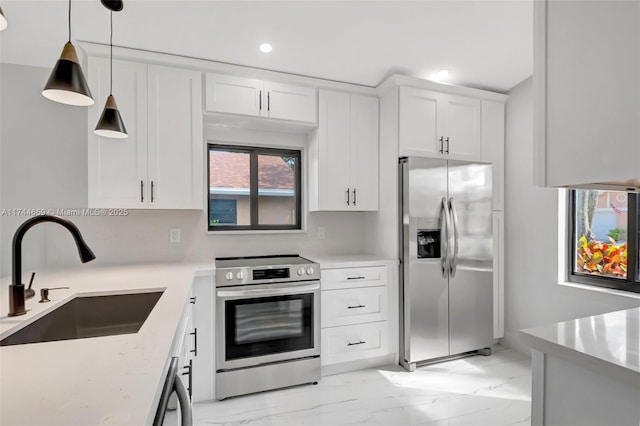 kitchen with stainless steel appliances, a sink, white cabinets, marble finish floor, and pendant lighting