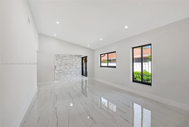 empty room featuring recessed lighting, marble finish floor, vaulted ceiling, and baseboards