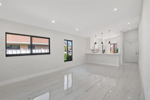 unfurnished living room with baseboards, marble finish floor, and recessed lighting