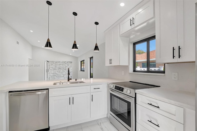 kitchen featuring white cabinets, appliances with stainless steel finishes, light countertops, pendant lighting, and a sink