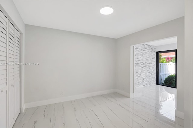 spare room with marble finish floor and baseboards