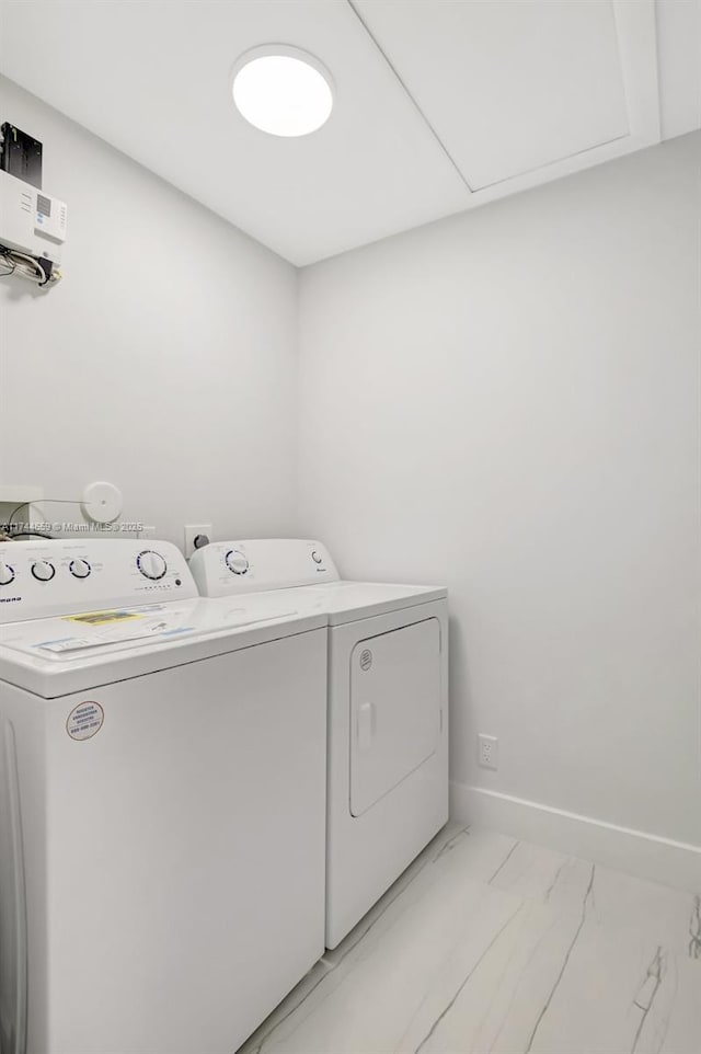 laundry room featuring laundry area, washing machine and dryer, marble finish floor, and baseboards