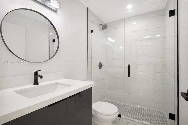 full bathroom with vanity, a marble finish shower, and toilet