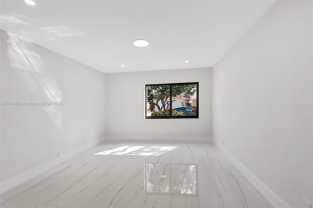 empty room featuring recessed lighting and baseboards