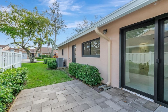 view of patio featuring central AC unit and fence