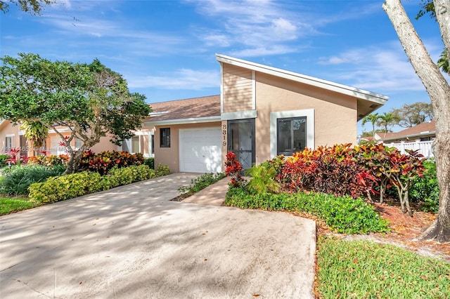 view of front of property featuring an attached garage, driveway, and stucco siding