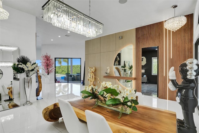 dining area with an inviting chandelier, a high ceiling, and tile patterned floors