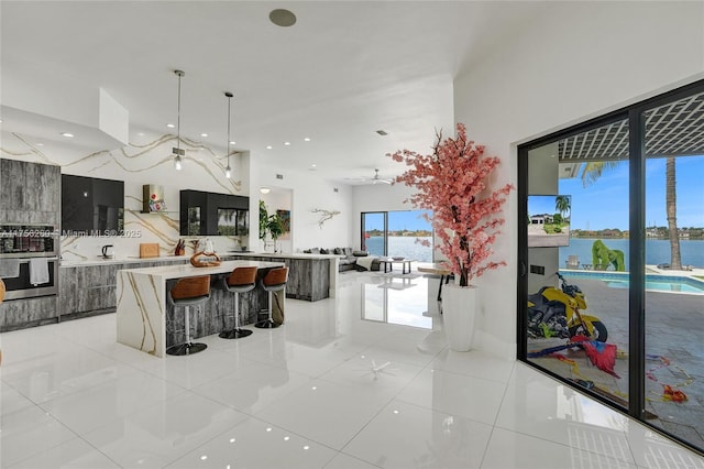 kitchen with a spacious island, light countertops, double oven, open floor plan, and modern cabinets