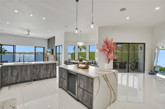 kitchen featuring open floor plan, modern cabinets, a sink, and light tile patterned flooring