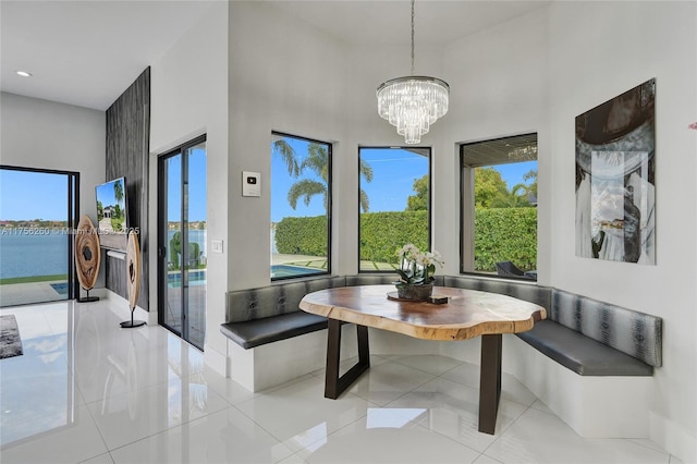 tiled dining area with breakfast area, a chandelier, a wealth of natural light, and recessed lighting