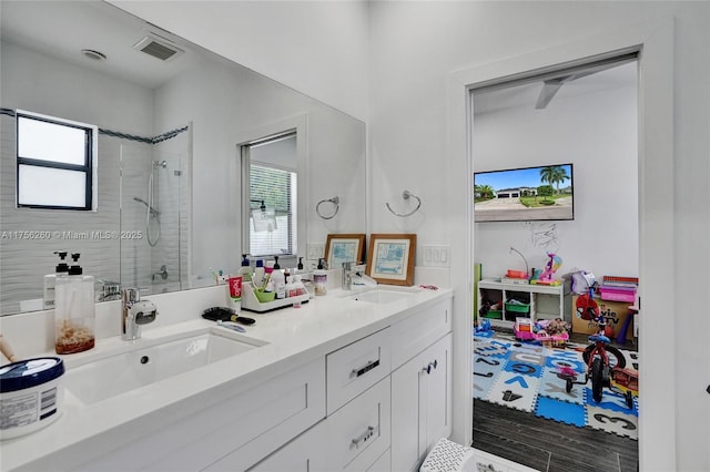 bathroom featuring a healthy amount of sunlight, a tile shower, and a sink