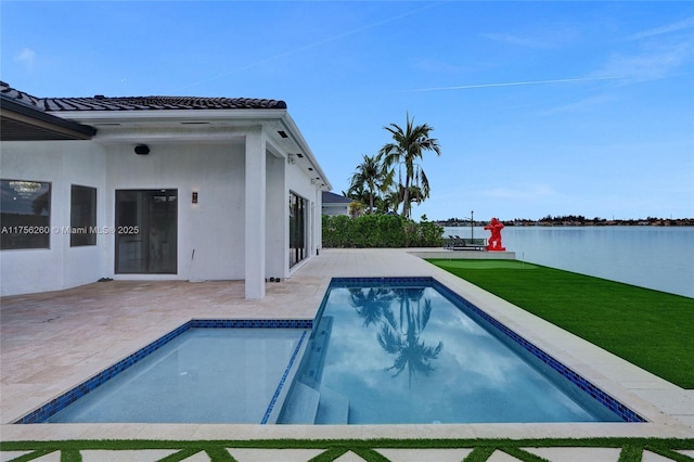 outdoor pool with a water view, a patio, and a lawn