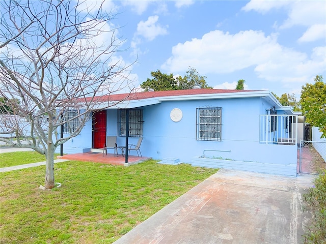 single story home featuring a front lawn, fence, and stucco siding