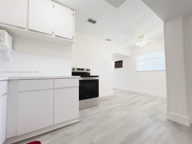 kitchen featuring stainless steel electric range, visible vents, white cabinets, and a ceiling fan