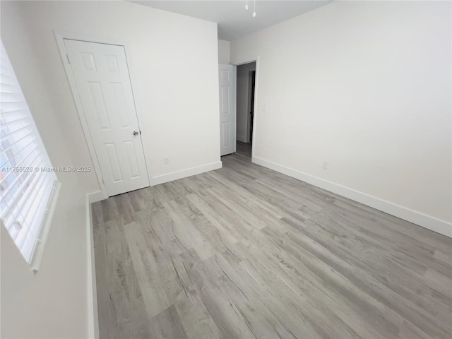 unfurnished bedroom with wood finished floors and baseboards