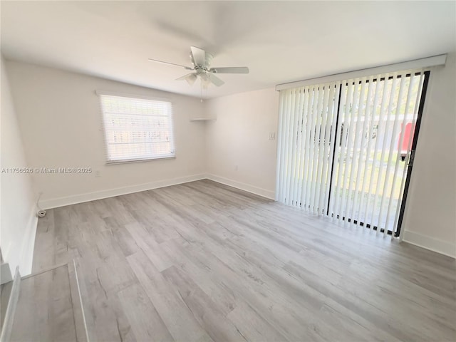 unfurnished room featuring baseboards, wood finished floors, and a healthy amount of sunlight