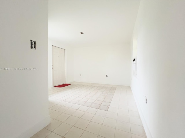 unfurnished room featuring light tile patterned flooring and baseboards