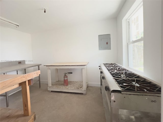 kitchen featuring electric panel, baseboards, and concrete flooring