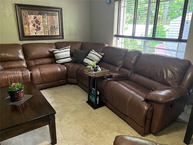 living area with a textured wall and light tile patterned floors