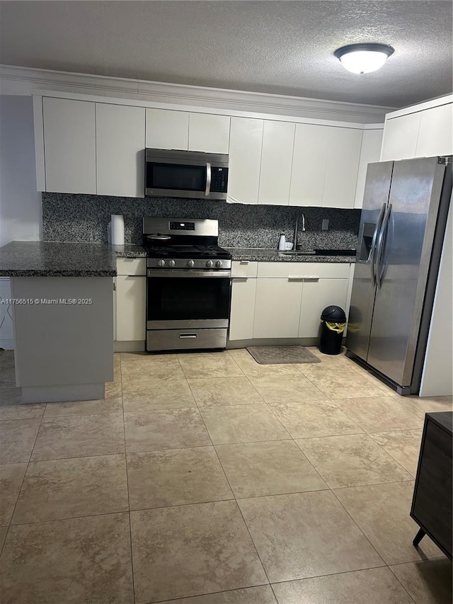 kitchen with a textured ceiling, appliances with stainless steel finishes, backsplash, and white cabinetry