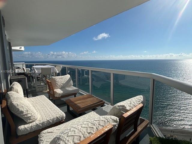 balcony with a water view and an outdoor living space