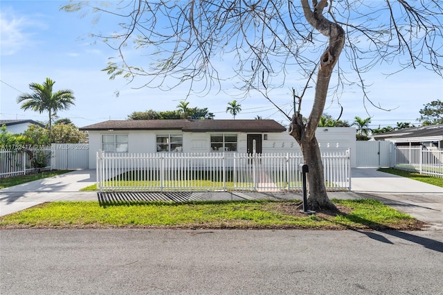 view of front of property featuring a fenced front yard, a gate, driveway, and stucco siding