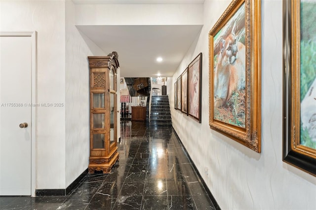 corridor featuring stairs, marble finish floor, and baseboards