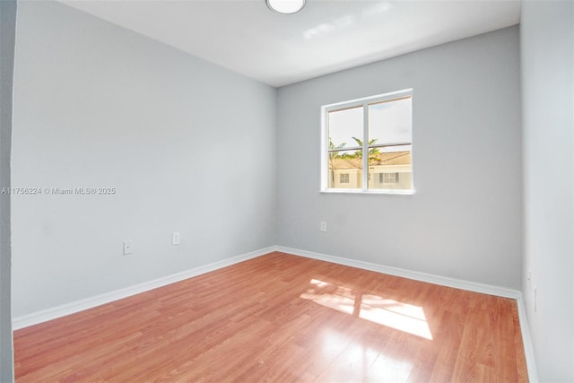 empty room with light wood-type flooring and baseboards