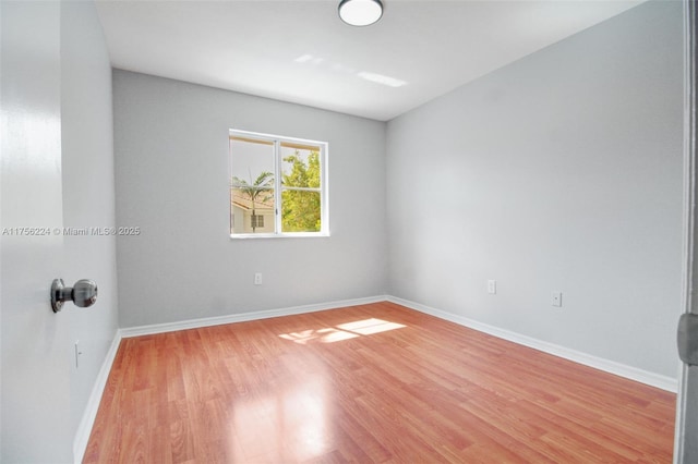 empty room with baseboards and light wood finished floors