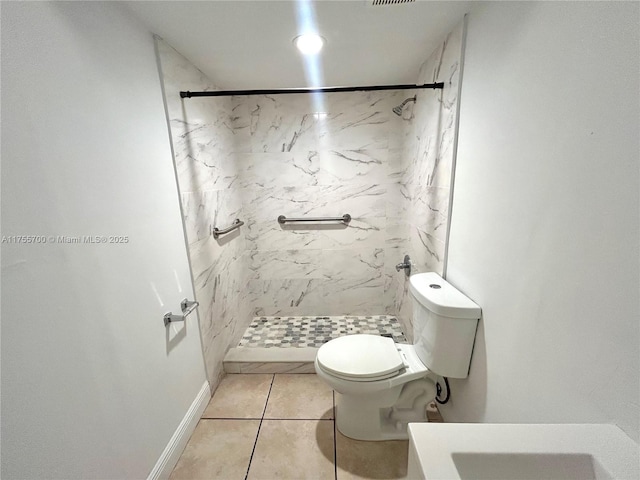 full bathroom with a stall shower, baseboards, toilet, and tile patterned floors