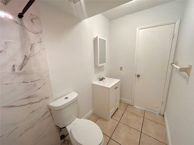 bathroom featuring toilet, tile patterned flooring, baseboards, and vanity