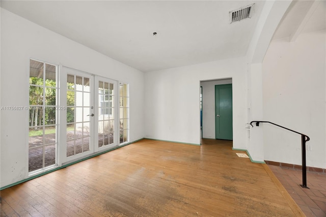 spare room with french doors, visible vents, baseboards, and hardwood / wood-style flooring