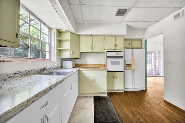 kitchen with light countertops, white appliances, visible vents, and a sink