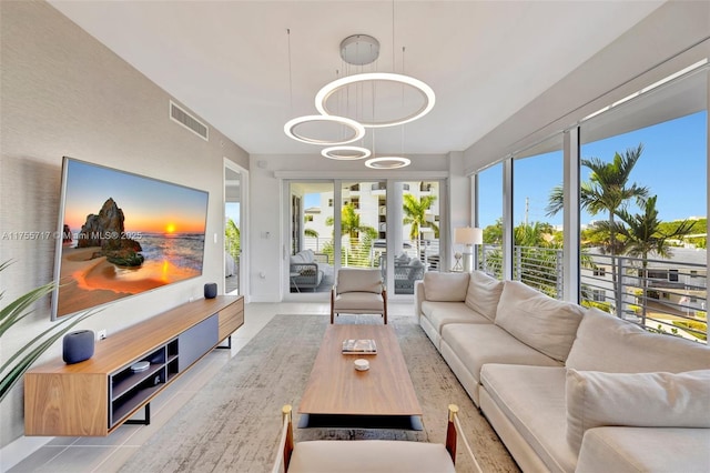 living area with a chandelier, french doors, visible vents, and tile patterned floors