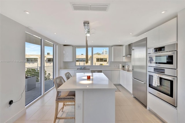 kitchen with appliances with stainless steel finishes, a sink, modern cabinets, and visible vents