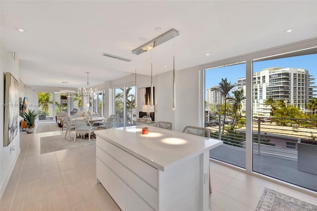 kitchen with white cabinets, modern cabinets, a kitchen island, open floor plan, and light countertops