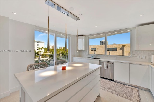 kitchen featuring decorative backsplash, dishwasher, and white cabinetry