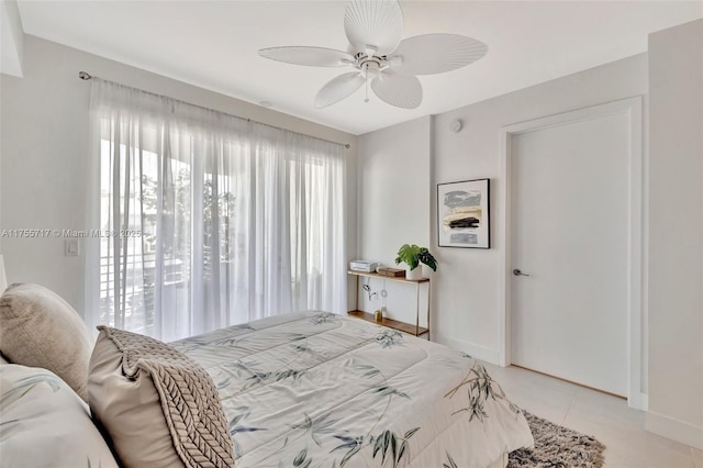 bedroom with light tile patterned floors, a ceiling fan, and baseboards