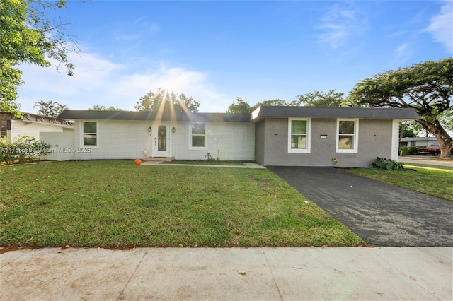 single story home with driveway and a front yard