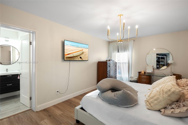 bedroom with baseboards, light wood finished floors, a sink, and an inviting chandelier