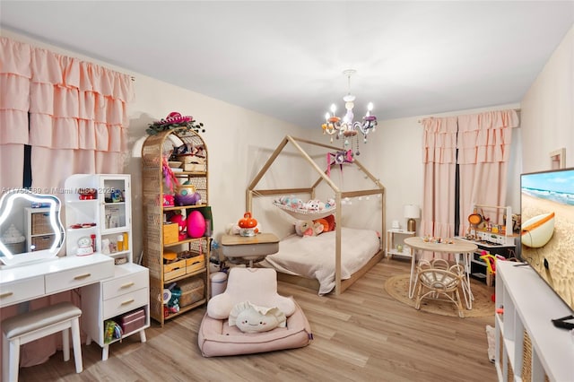 bedroom featuring light wood-style flooring and an inviting chandelier