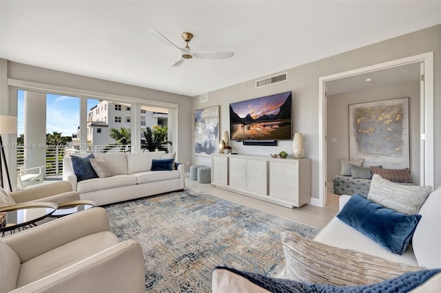 tiled living room featuring baseboards, a ceiling fan, and visible vents