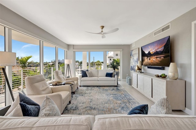 living area with visible vents, baseboards, and ceiling fan