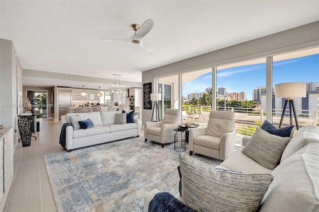 tiled living room featuring a city view and ceiling fan with notable chandelier