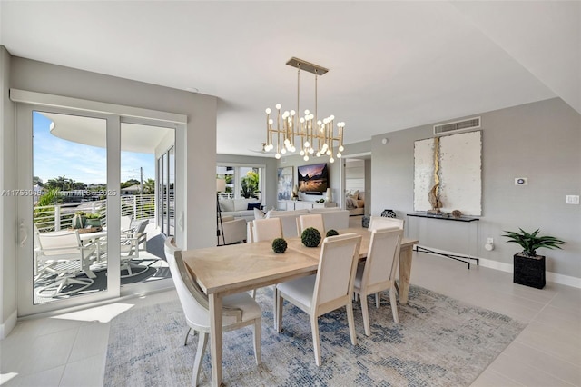 dining area with tile patterned floors, an inviting chandelier, baseboards, and visible vents